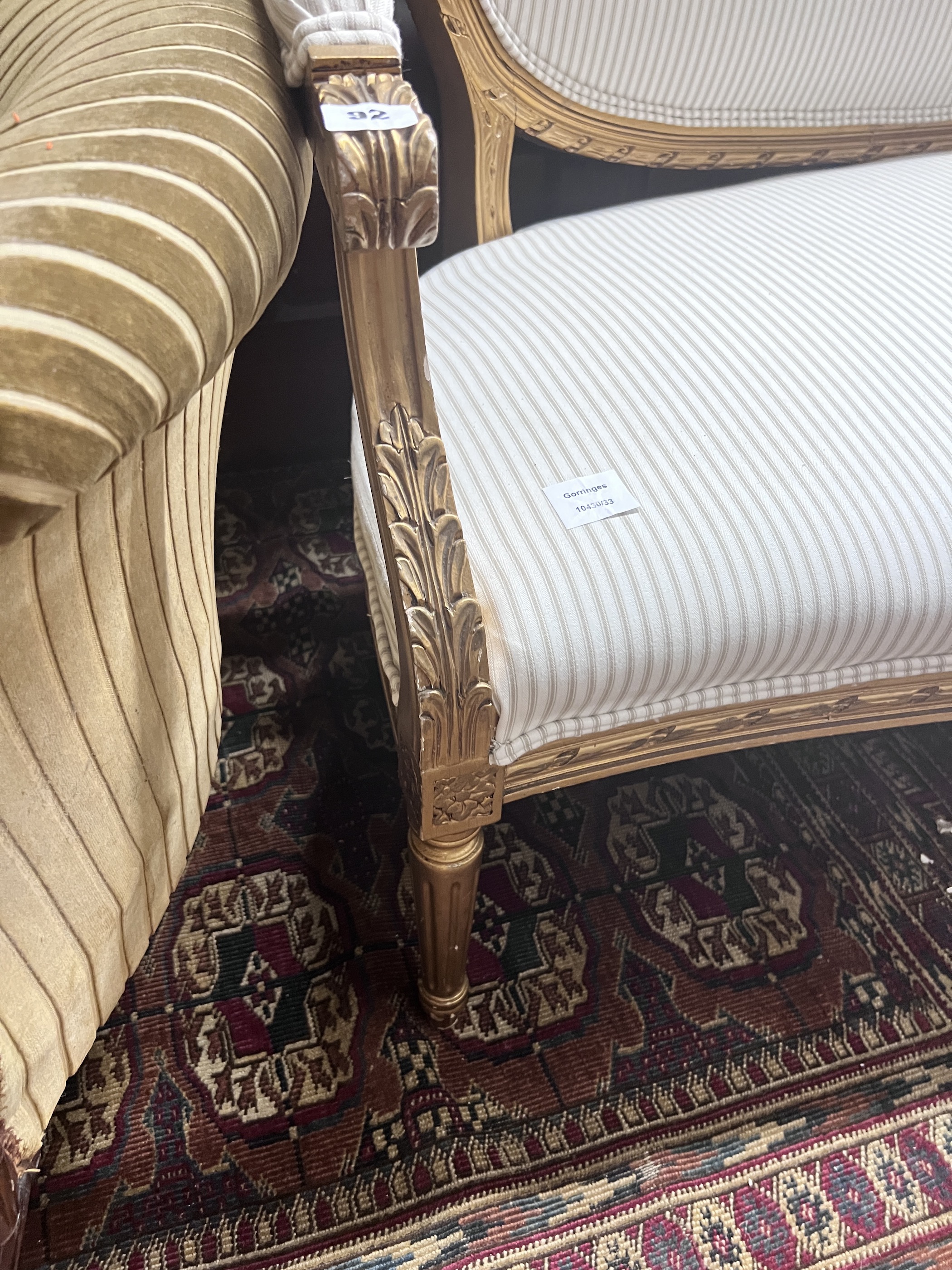 A French giltwood and composition settee, recently re-upholstered in a striped linen fabric, width 140cm, depth 60cm, height 92cm